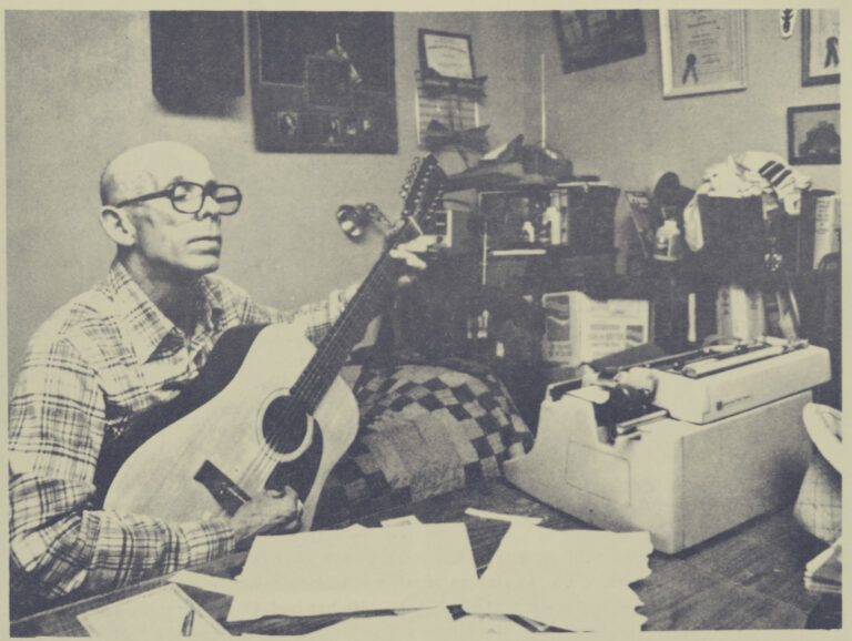 Johnny Mullins playing guitar and writing a song in his home study in Springfield, MO approx 1980